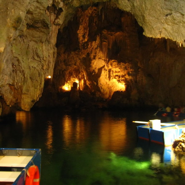 Le barche dentro la Grotta dello Smeraldo, tra stalattiti illuminate e riflessi verdi